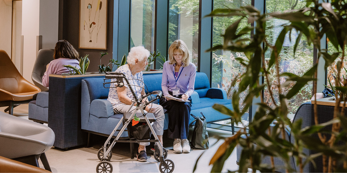 Patient sat reviewing clipboard with healthcare professional 